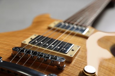 Photo of Modern electric guitar on grey background, closeup