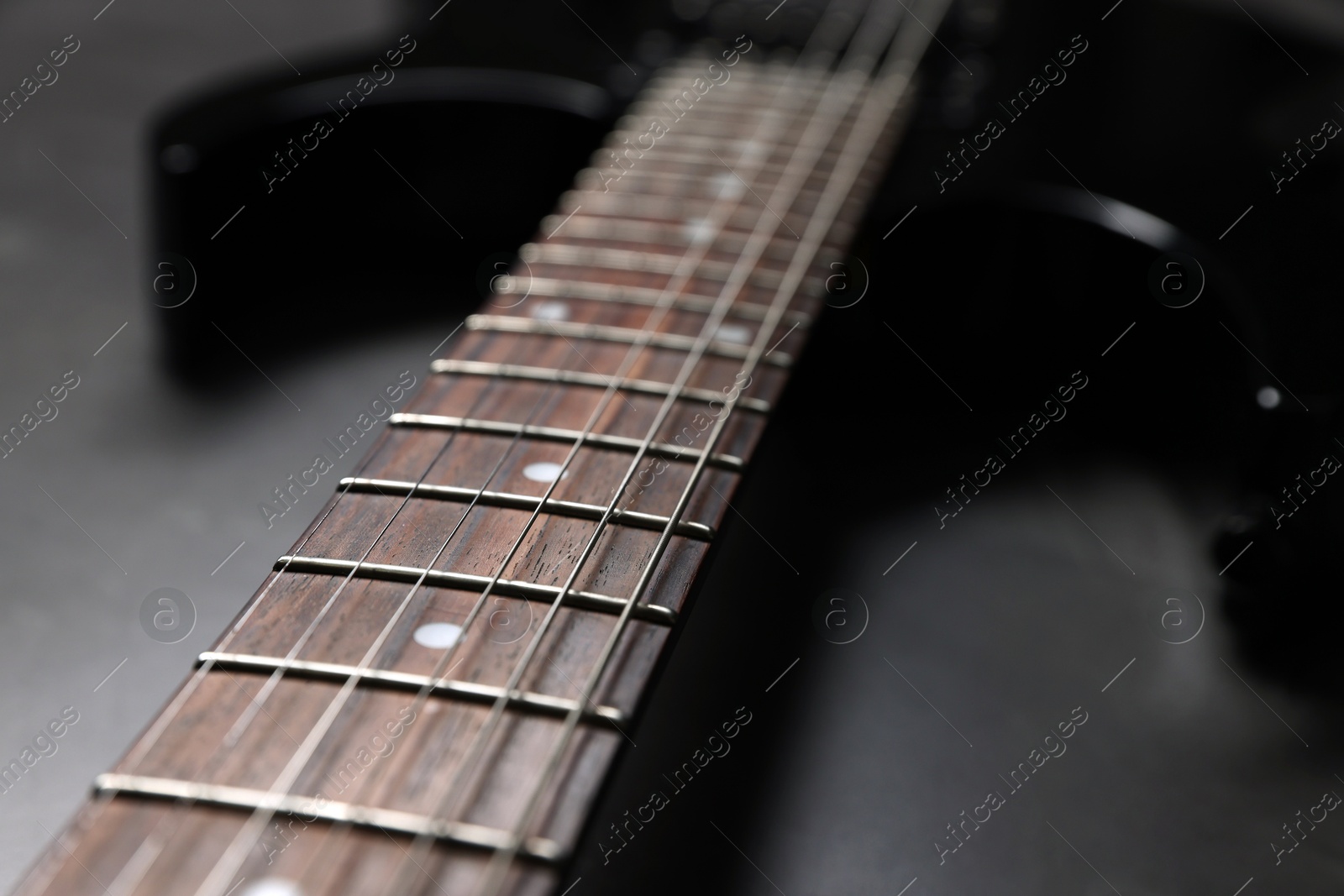 Photo of Modern electric guitar on black background, closeup