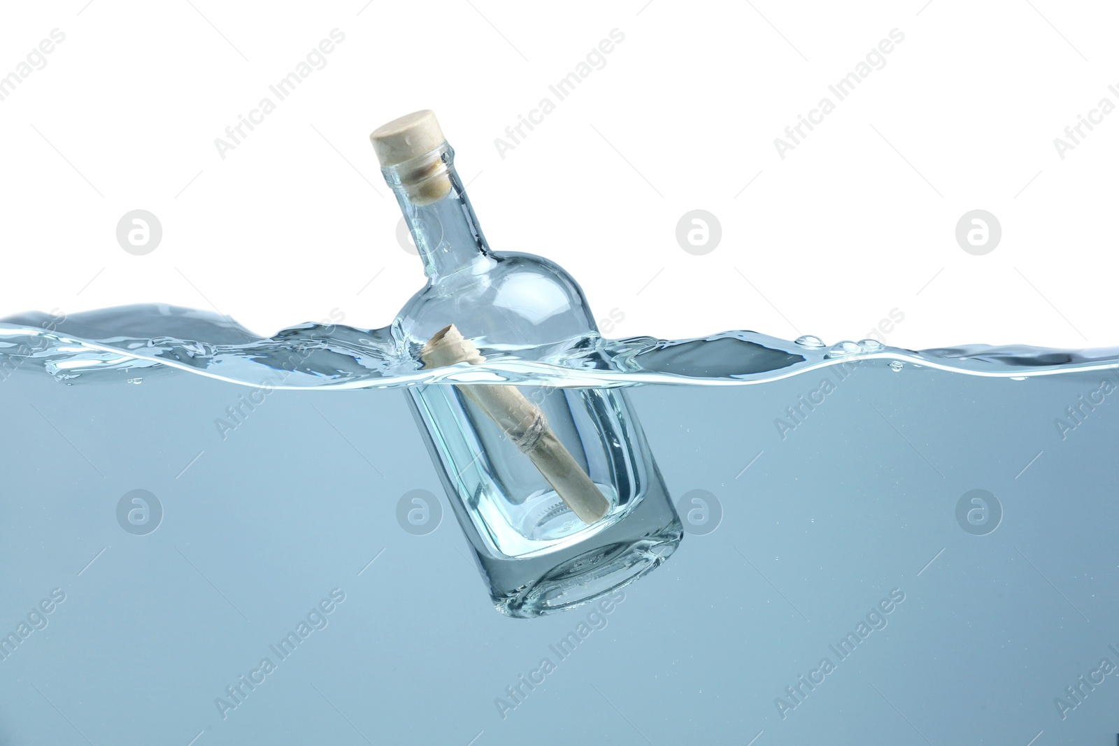 Photo of Corked glass bottle with rolled letter in water on white background