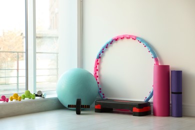 Different fitness equipment near white wall indoors