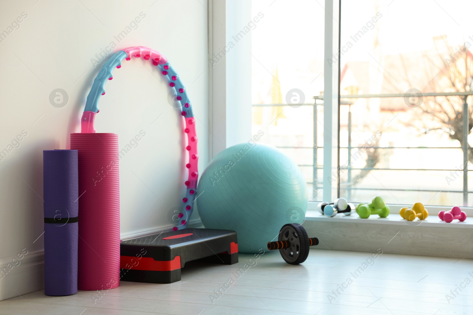 Photo of Different fitness equipment near white wall indoors