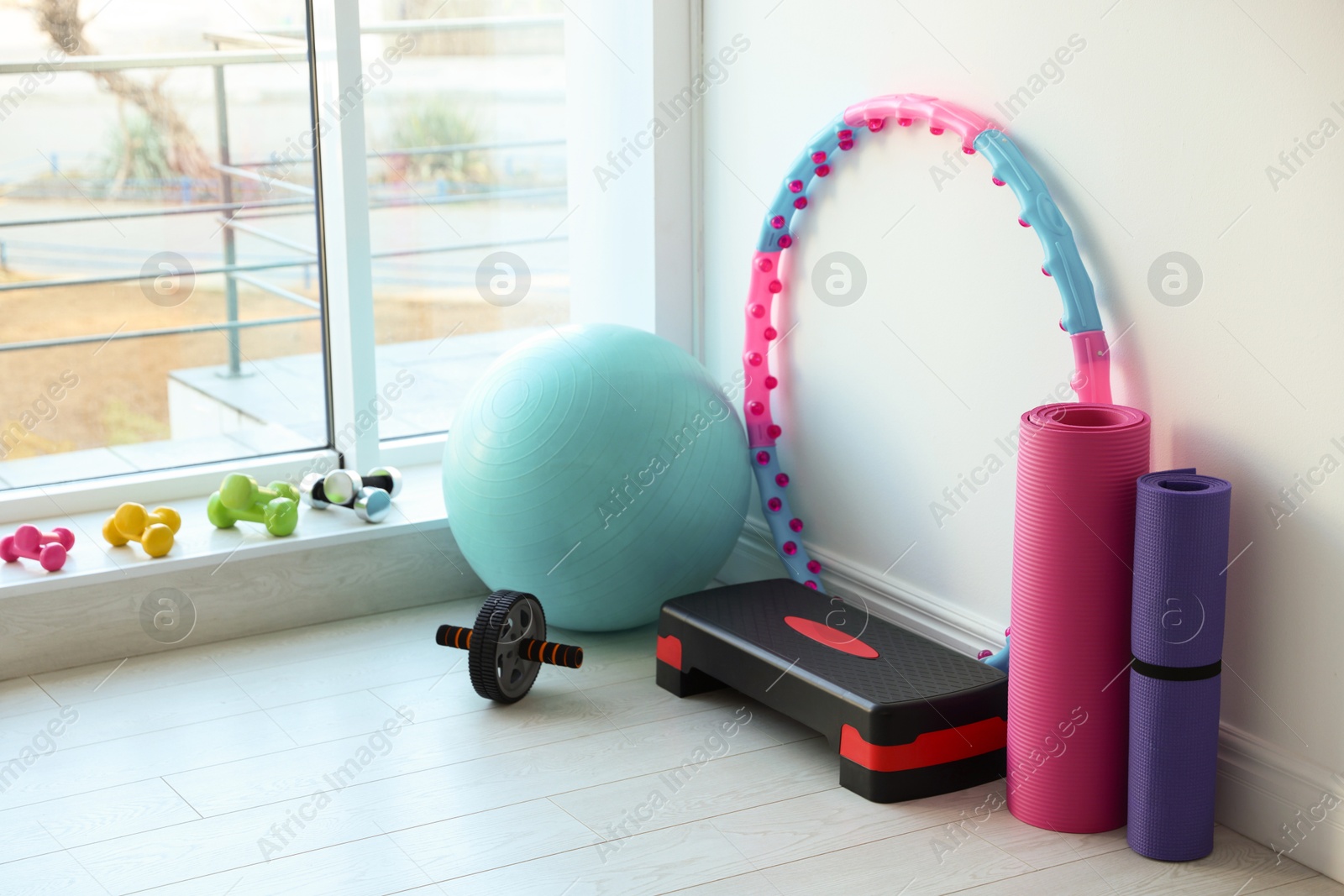 Photo of Different fitness equipment near white wall indoors