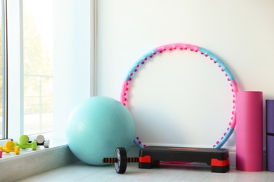 Different fitness equipment near white wall indoors