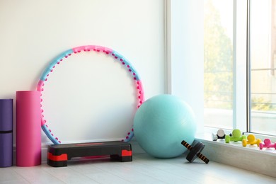 Photo of Different fitness equipment near white wall indoors