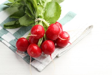 Photo of Bunch of fresh radishes on white wooden table, closeup