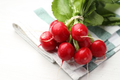 Photo of Bunch of fresh radishes on white wooden table, closeup