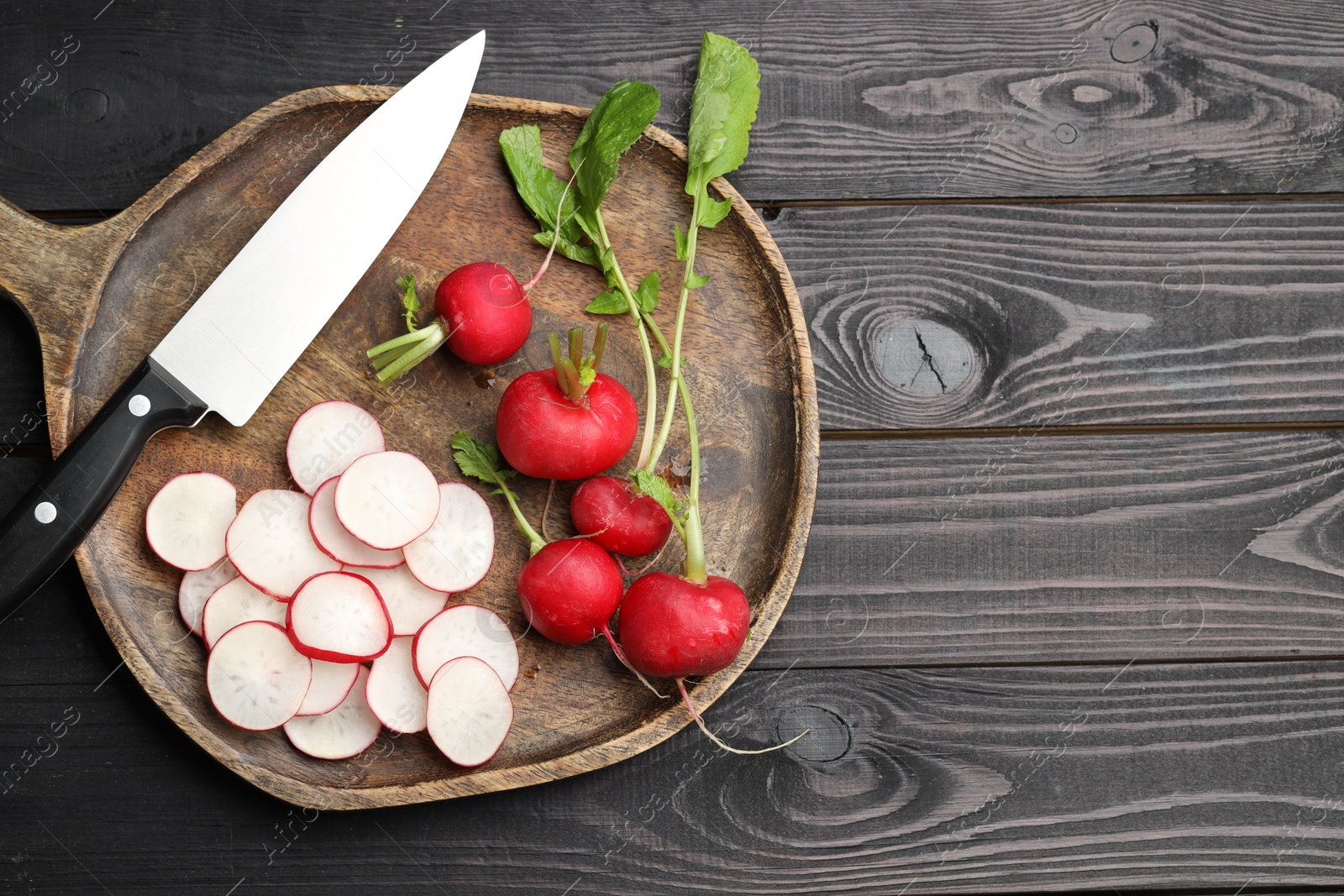 Many fresh radishes and knife on black wooden table, top view. Space for text Photo of Many fresh radishes and knife on black wooden table, top view. Space for text