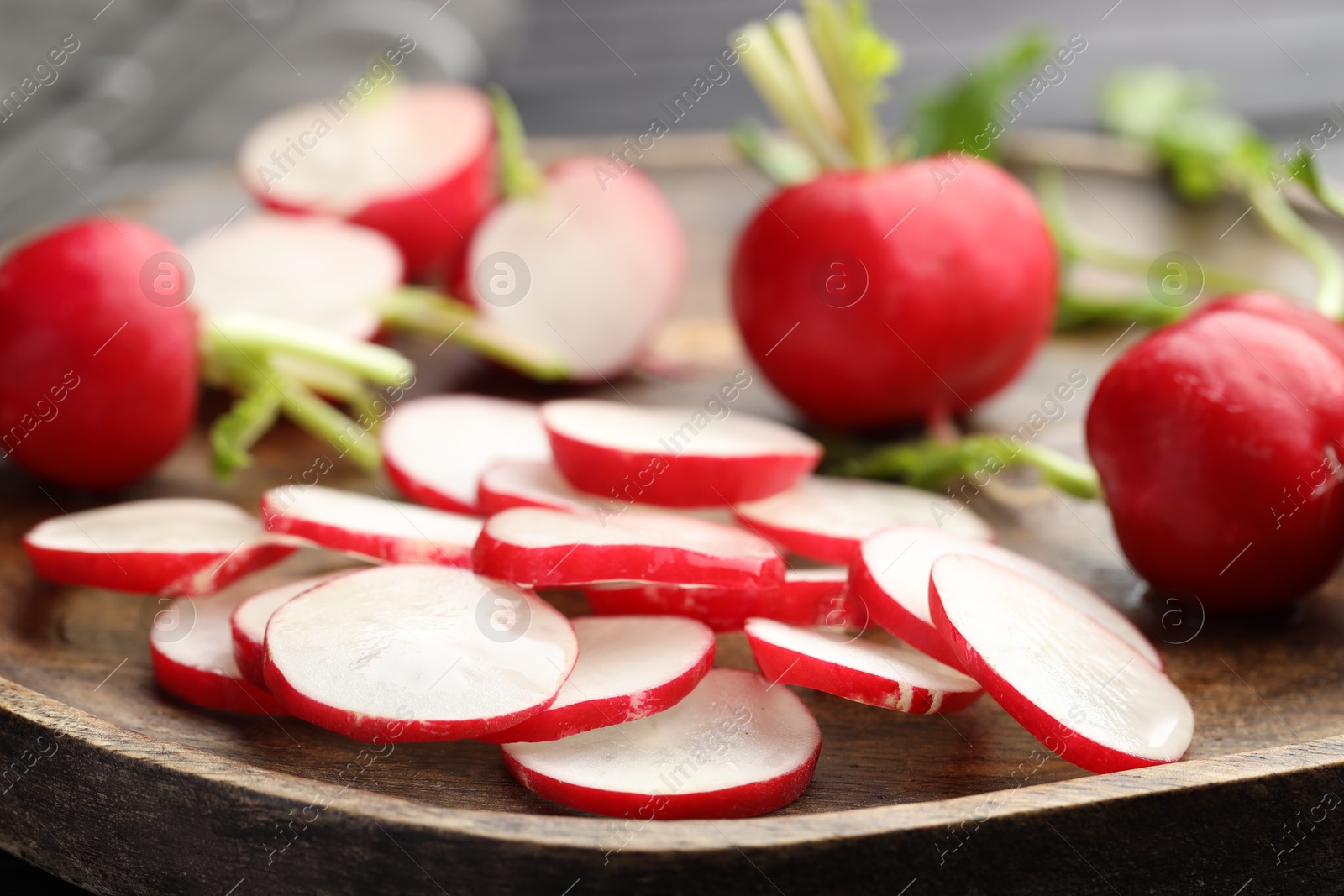 Fresh whole and cut radishes on wooden board, closeup Photo of Fresh whole and cut radishes on wooden board, closeup
