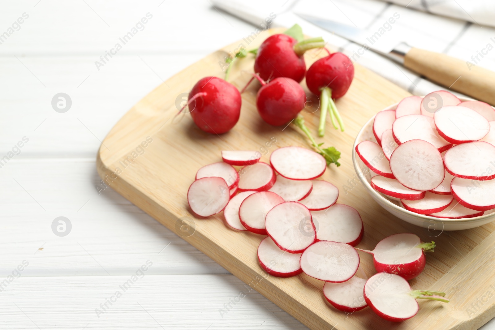 Fresh whole and cut radishes on white wooden table, closeup Photo of Fresh whole and cut radishes on white wooden table, closeup