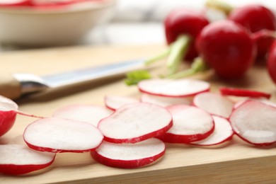 Photo of Slices of fresh radishes on wooden board, closeup
