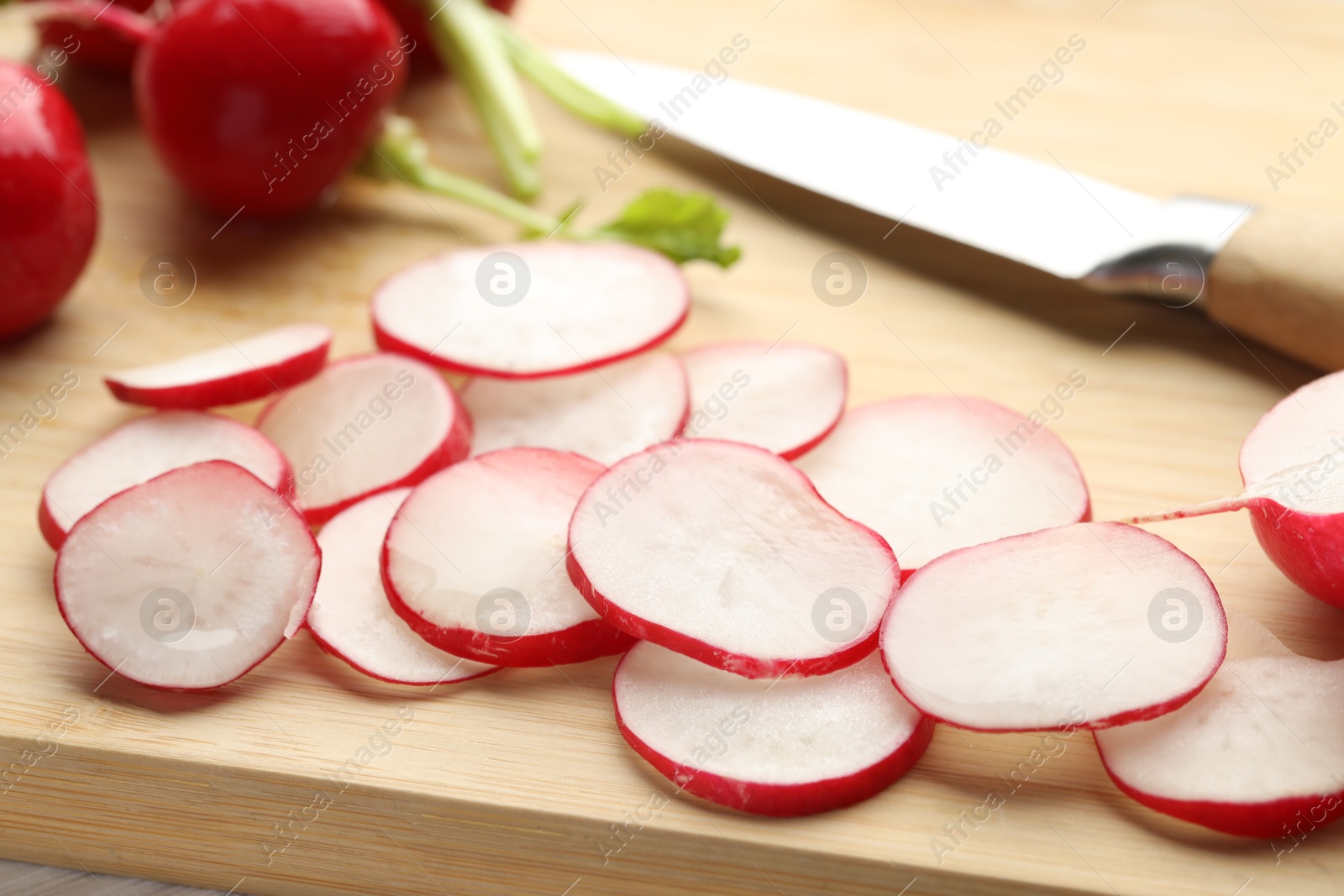 Photo of Fresh whole and cut radishes on table, closeup