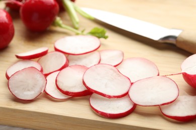 Photo of Fresh whole and cut radishes on table, closeup