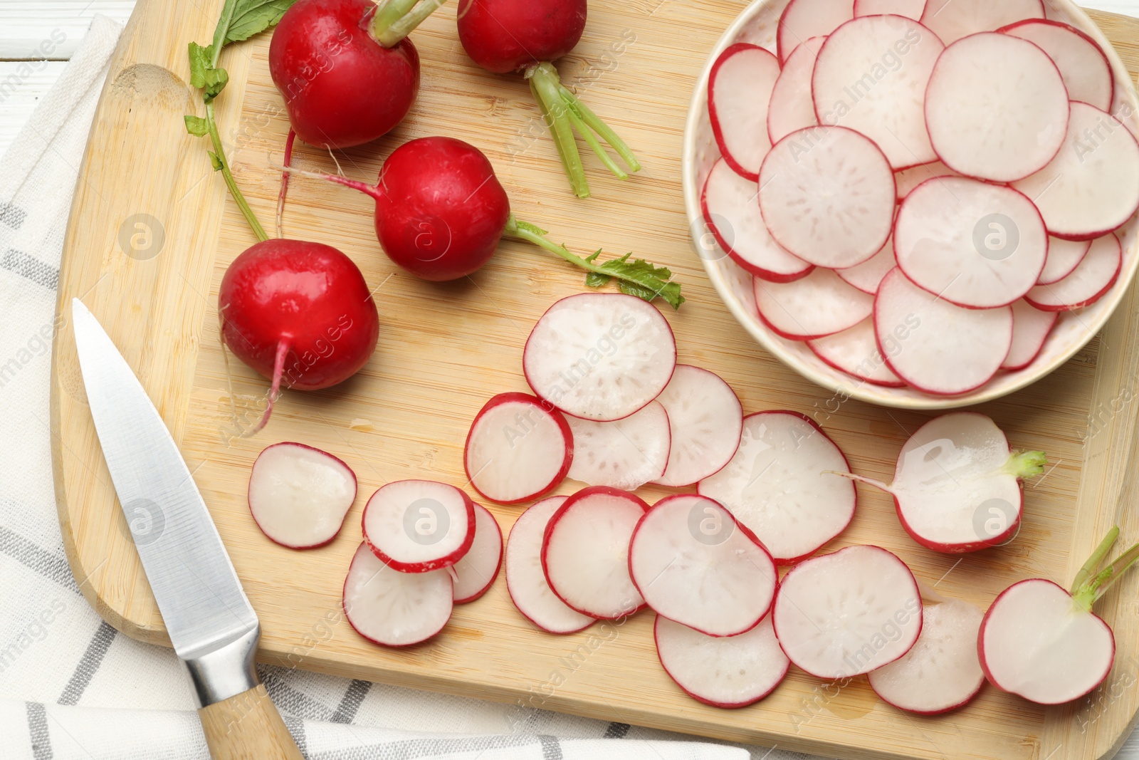 Many fresh radishes and knife on white wooden table, top view Photo of Many fresh radishes and knife on white wooden table, top view