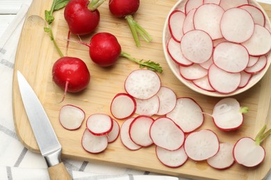 Photo of Many fresh radishes and knife on white wooden table, top view