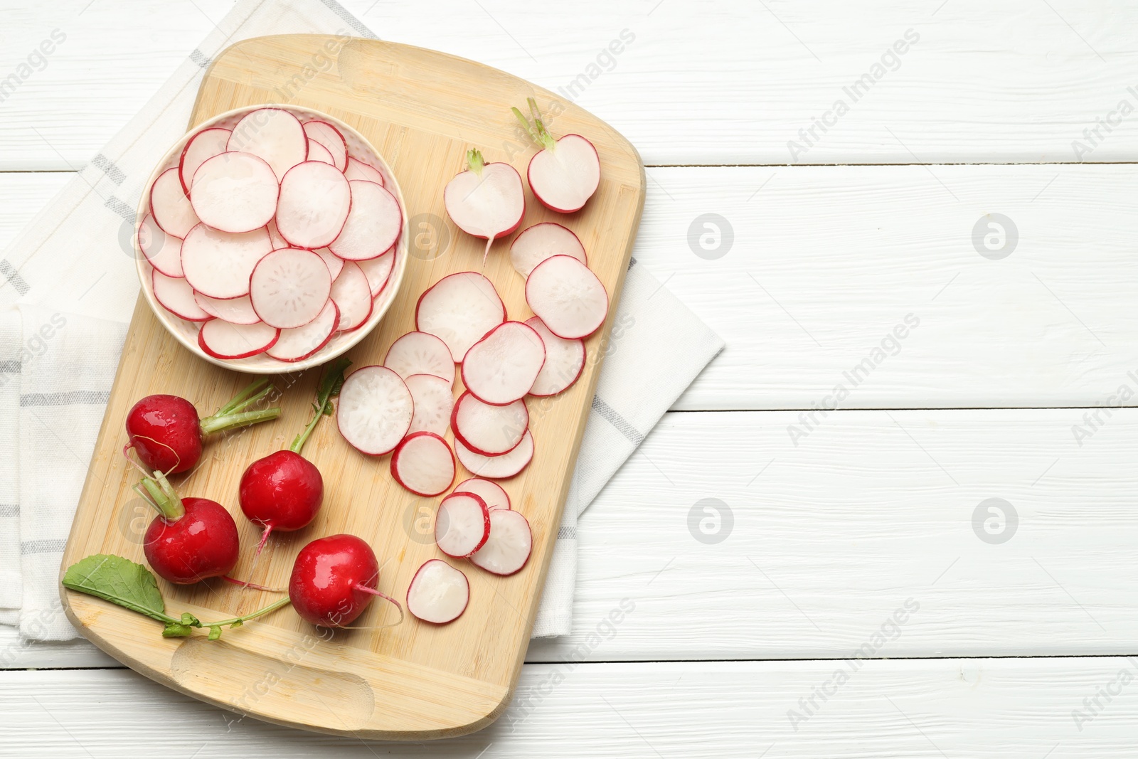 Fresh whole and cut radishes on white wooden table, top view. Space for text Photo of Fresh whole and cut radishes on white wooden table, top view. Space for text