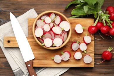 Photo of Many fresh radishes and knife on wooden table, flat lay