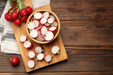 Photo of Fresh cut and whole radishes on wooden table, flat lay. Space for text