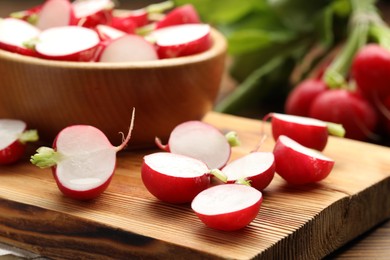 Photo of Fresh cut radishes on wooden table, closeup