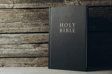 Hardcover Holy Bible on grey table, space for text