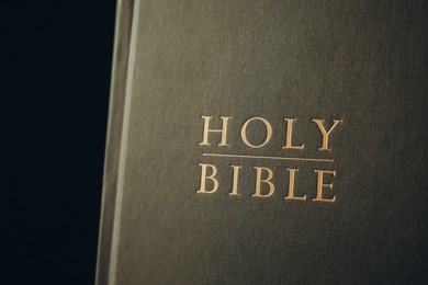 Photo of Hardcover Holy Bible on black background, closeup