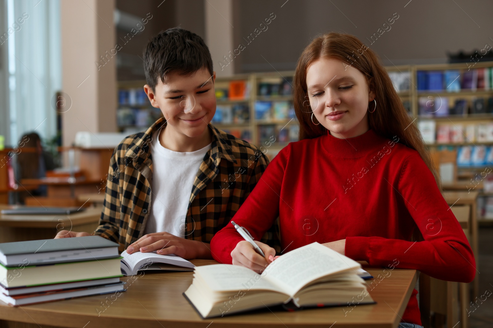 Photo of Students studying together at desk in public library