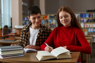 Photo of Students studying together at desk in public library