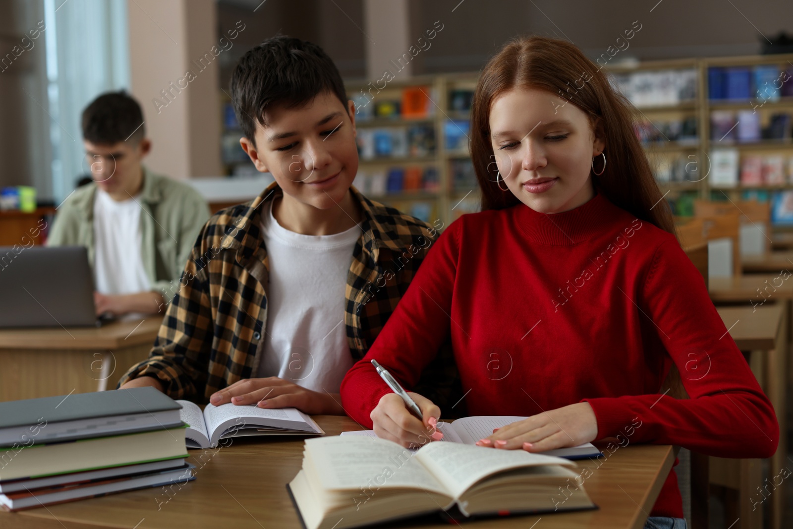 Photo of Students studying together at desk in public library