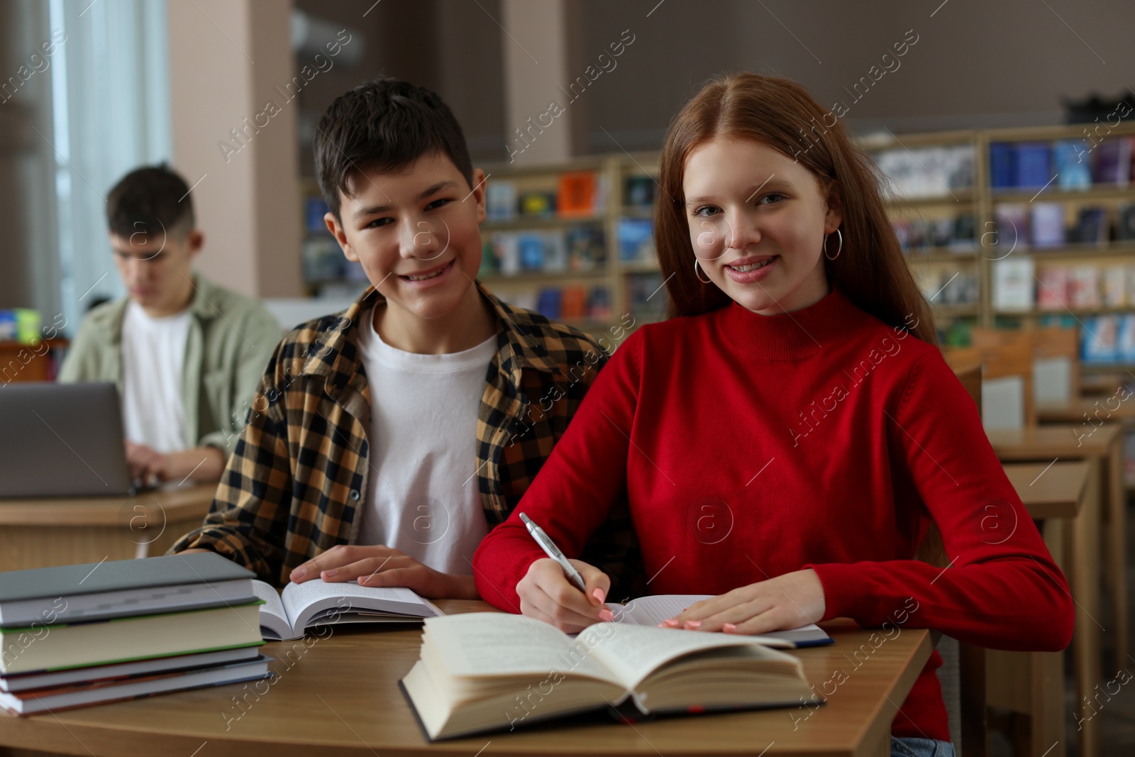 Photo of Students studying together at desk in public library