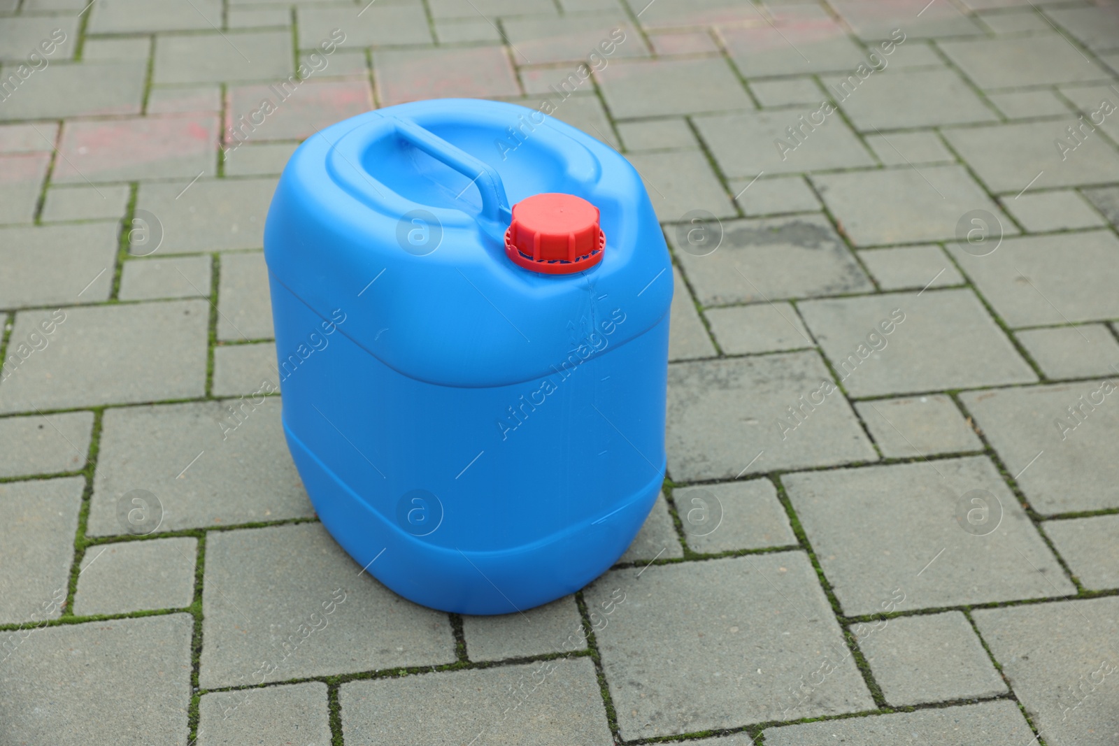 Photo of One blue plastic canister on pavement outdoors