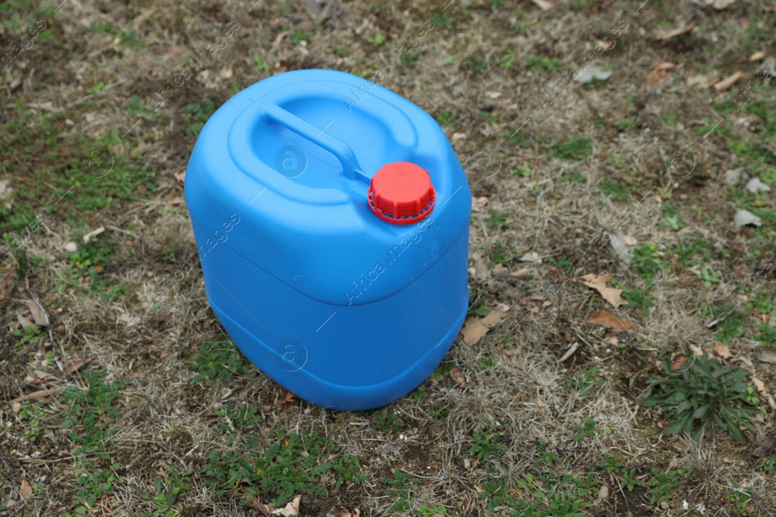 Photo of One blue plastic canister on ground outdoors