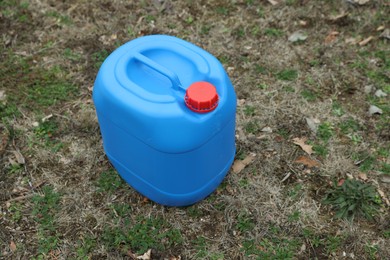 One blue plastic canister on ground outdoors