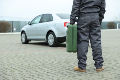 Photo of Man with khaki metal canister outdoors, closeup