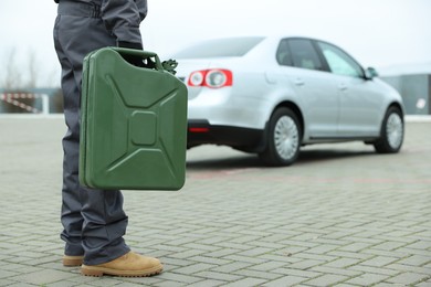 Photo of Man with khaki metal canister outdoors, closeup