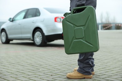 Photo of Man with khaki metal canister outdoors, closeup