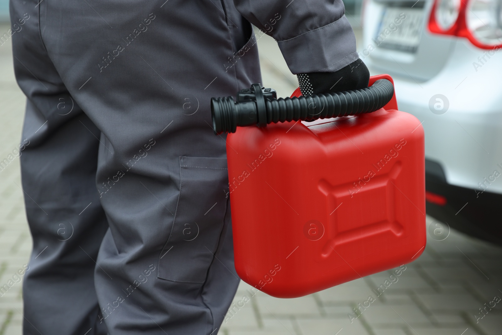 Photo of Man with canister near car outdoors, closeup