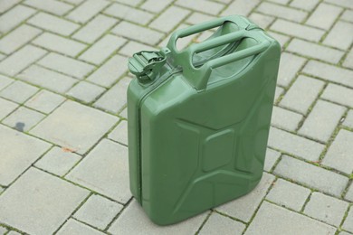 One khaki metal canister on pavement outdoors