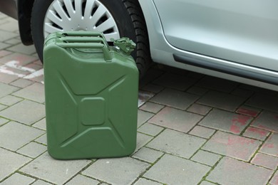 Khaki metal canister near modern car outdoors