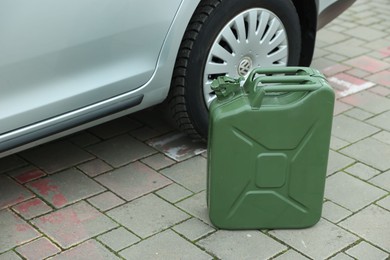 Khaki metal canister near modern car outdoors