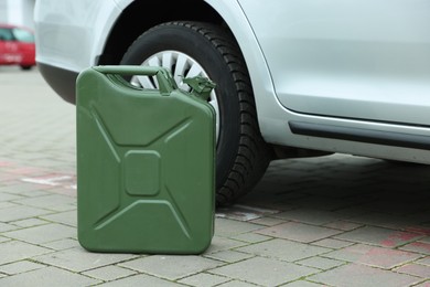 Khaki metal canister near modern car outdoors