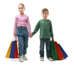 Cute little friends with shopping bags holding hands on white background