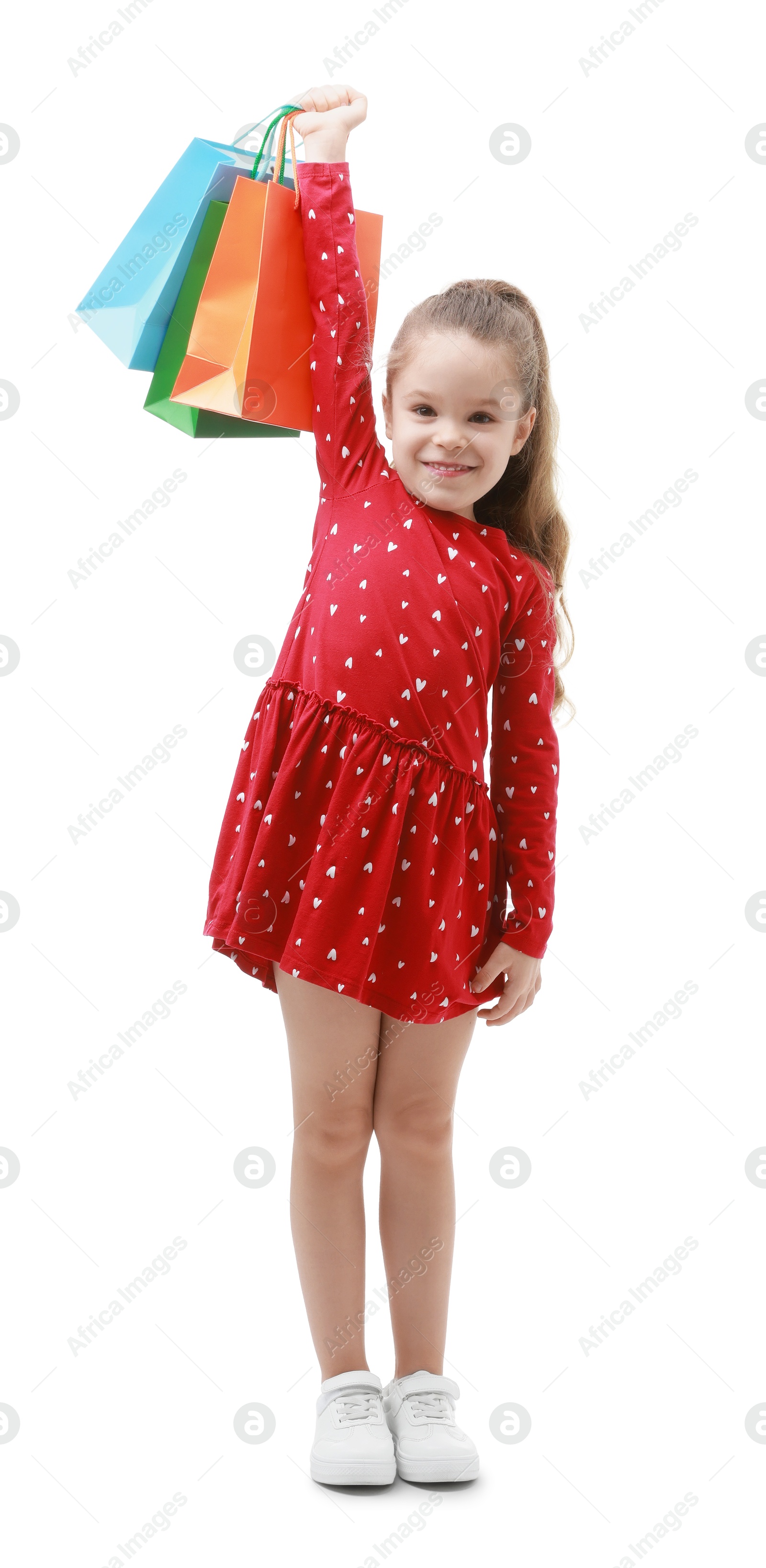 Photo of Happy little girl with shopping bags on white background