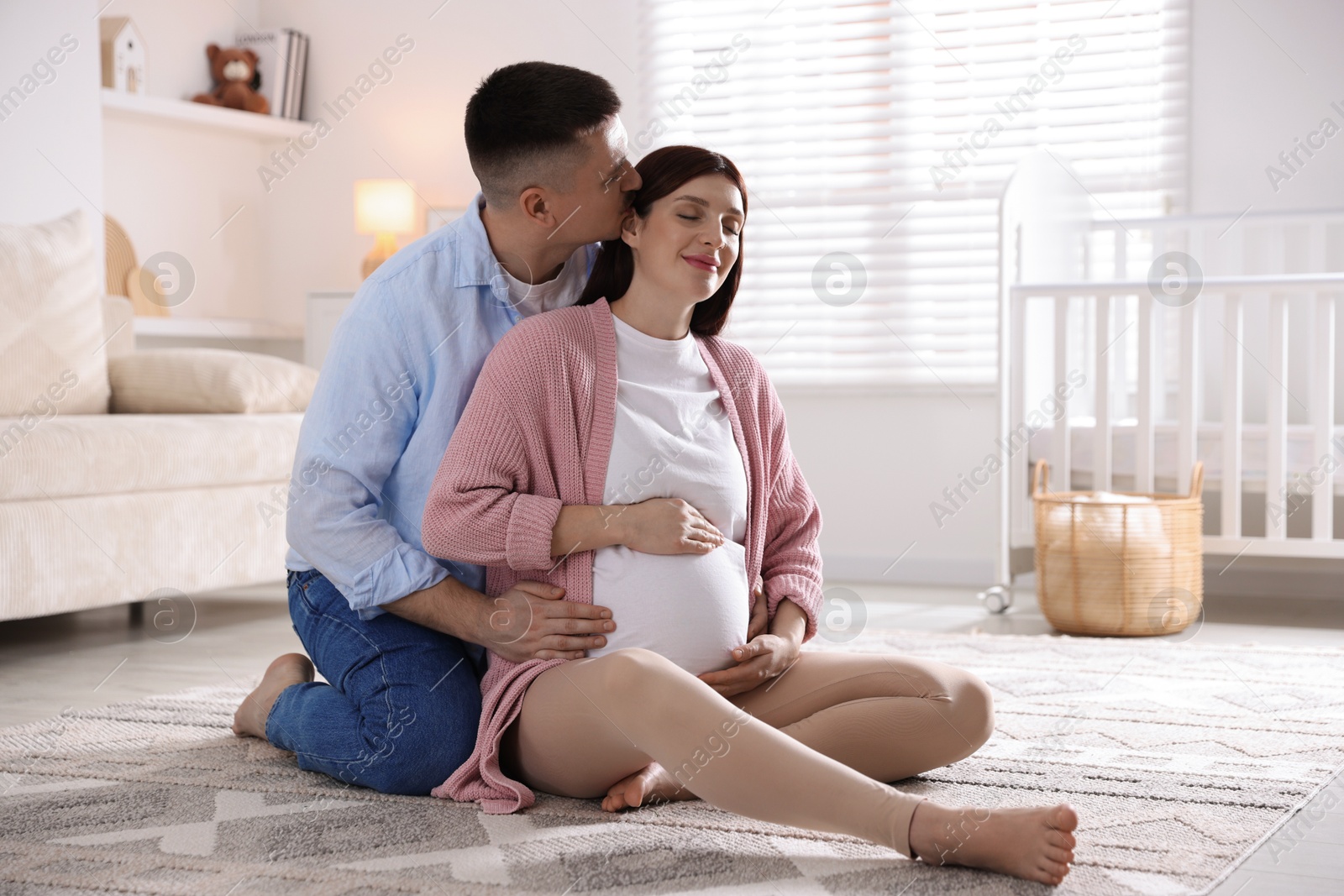 Photo of Pregnant woman and her husband on floor at home