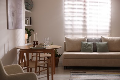 Photo of Stylish table setting, chairs and sofa in dining room. interior design