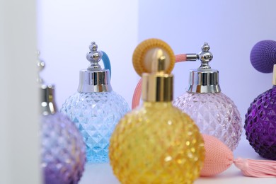 Photo of Different bottles of luxury perfume on shelf in store, closeup