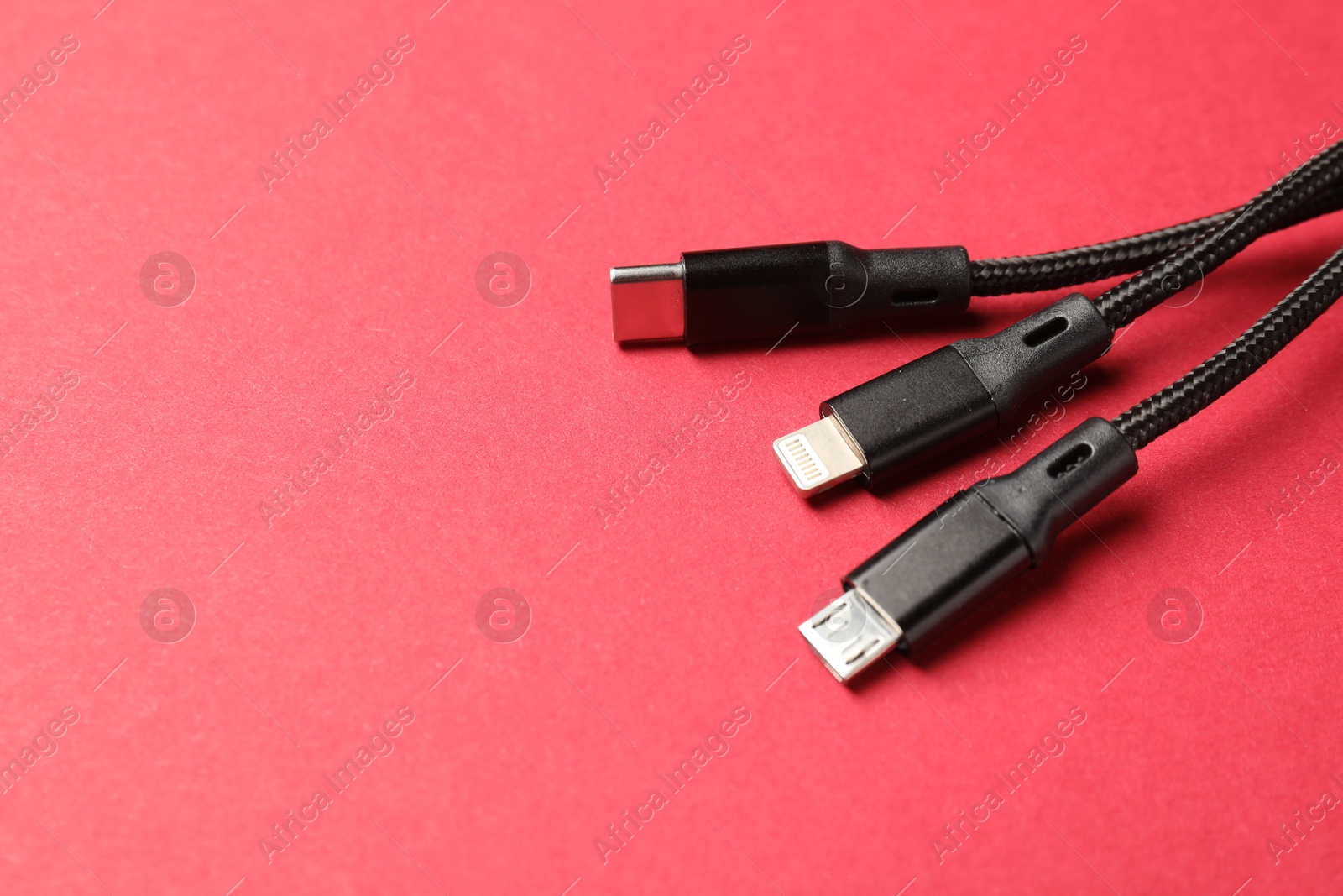 Photo of Triple charge cable on crimson, closeup. Space for text