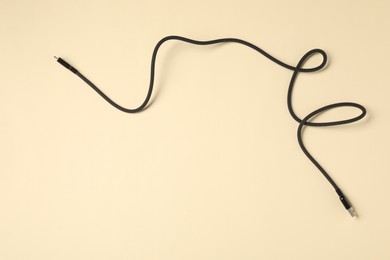 Photo of One USB charge cable on beige background, top view. Space for text