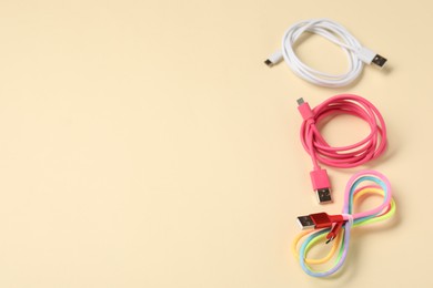 Photo of USB charge cables on beige background, above view. Space for text