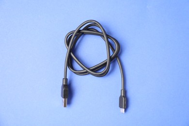 Photo of One USB charge cable on blue background, top view