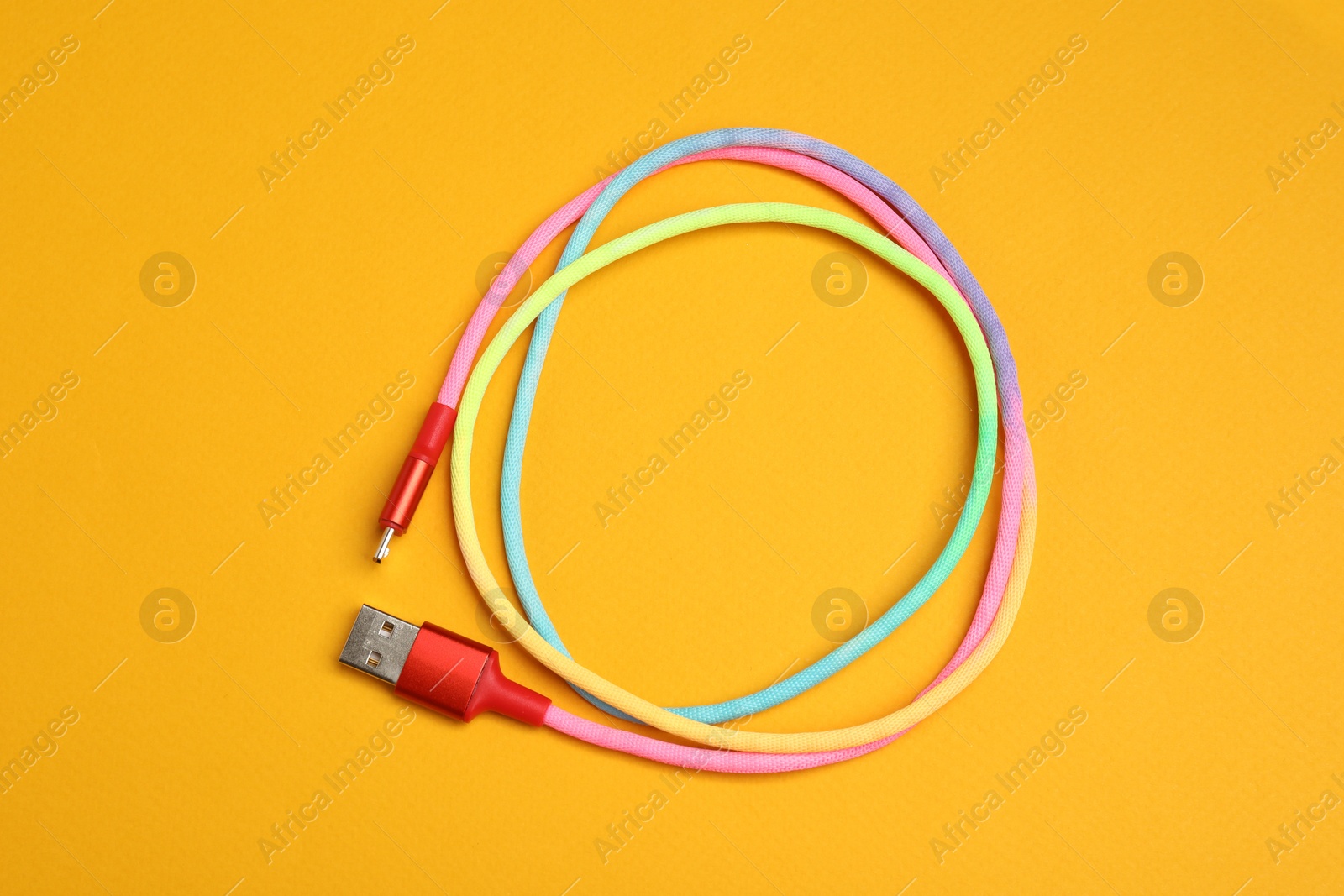 Photo of One USB charge cable on orange background, top view