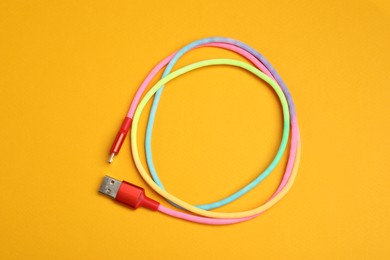 Photo of One USB charge cable on orange background, top view